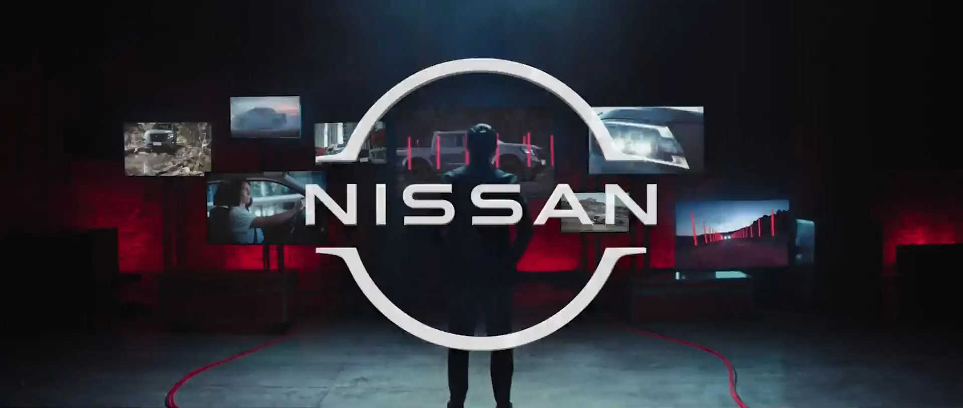 Imagem que destaca a marca Nissan em um ambiente futurista, com várias telas exibindo diferentes modelos e inovações automotivas.